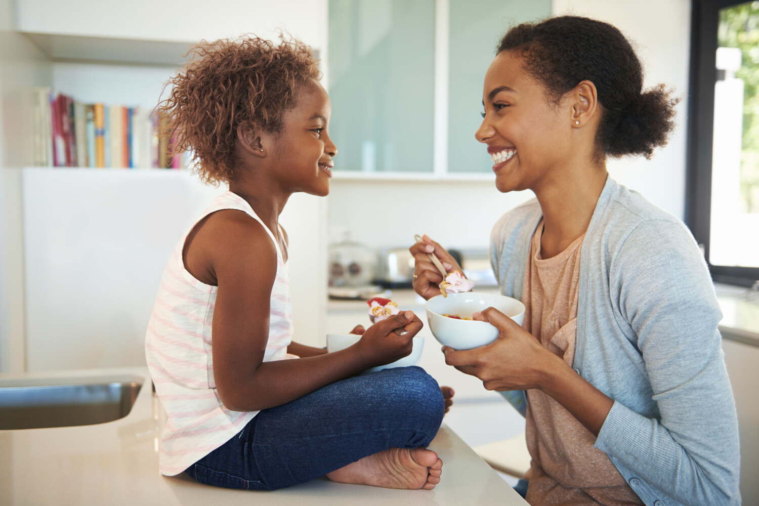 Shot of a mother and her little daughter eating breakfast in the kitchen