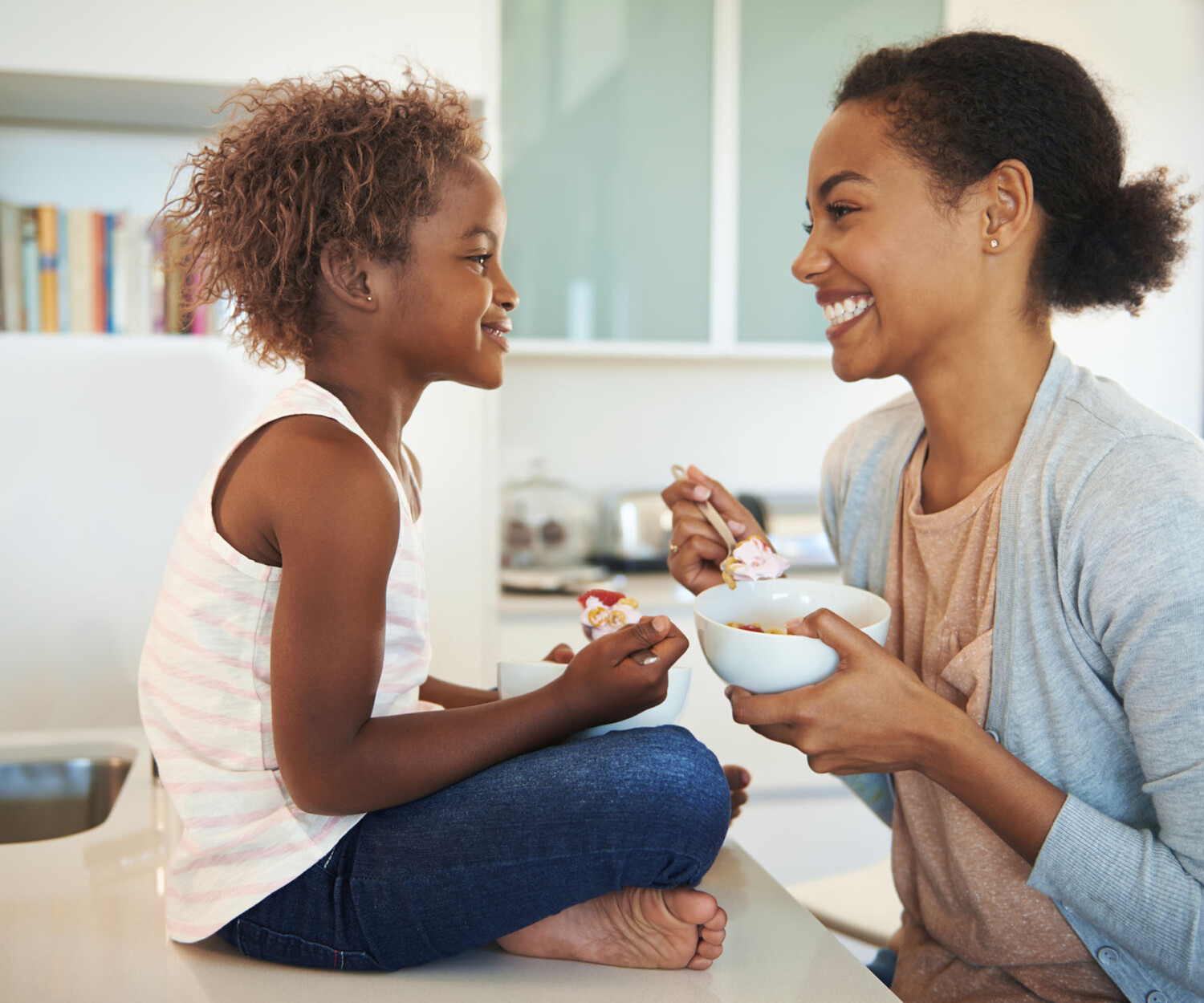 Shot of a mother and her little daughter eating breakfast in the kitchen